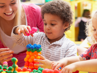 Image of an adult supervising two children playing