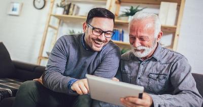 younger man and older looking at ipad